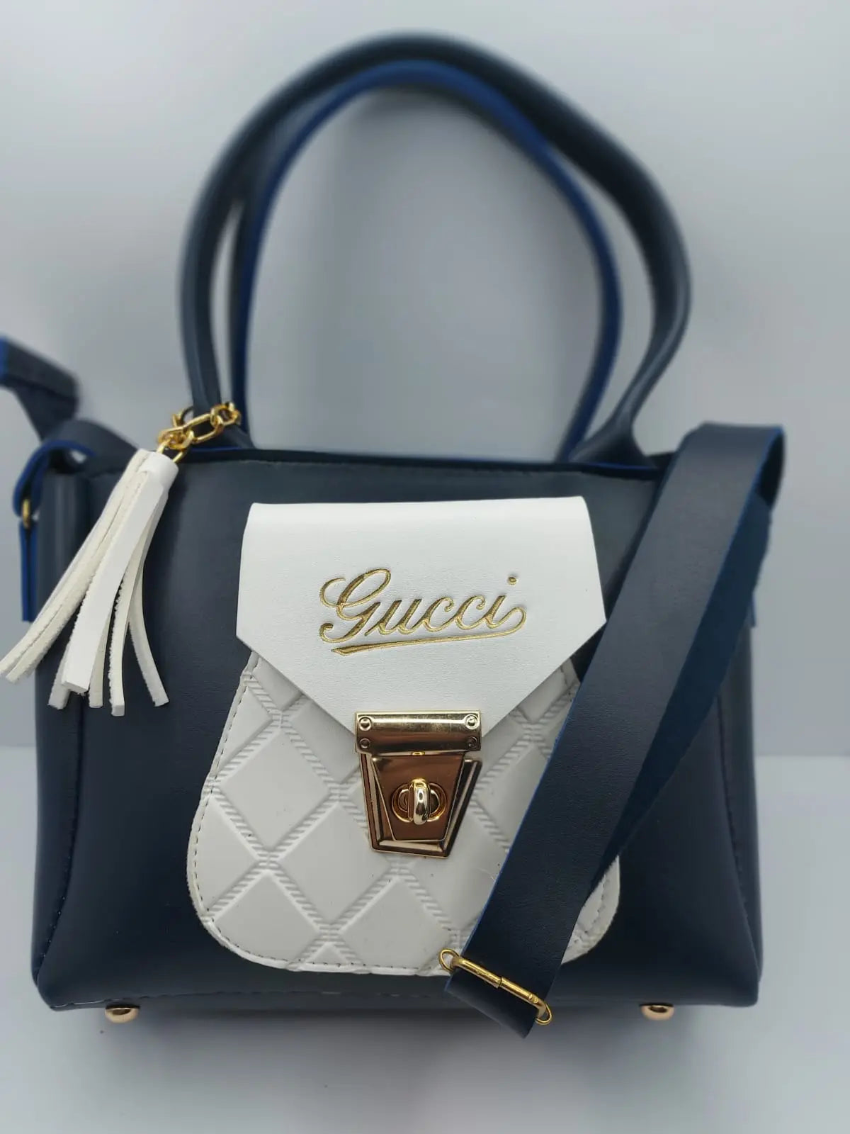 The Midnight Blue Quilted Mini Tote Bag offers a stylish blend of elegance and practicality with its quilted design, gold-tone Gucci logo, and versatile carrying options
