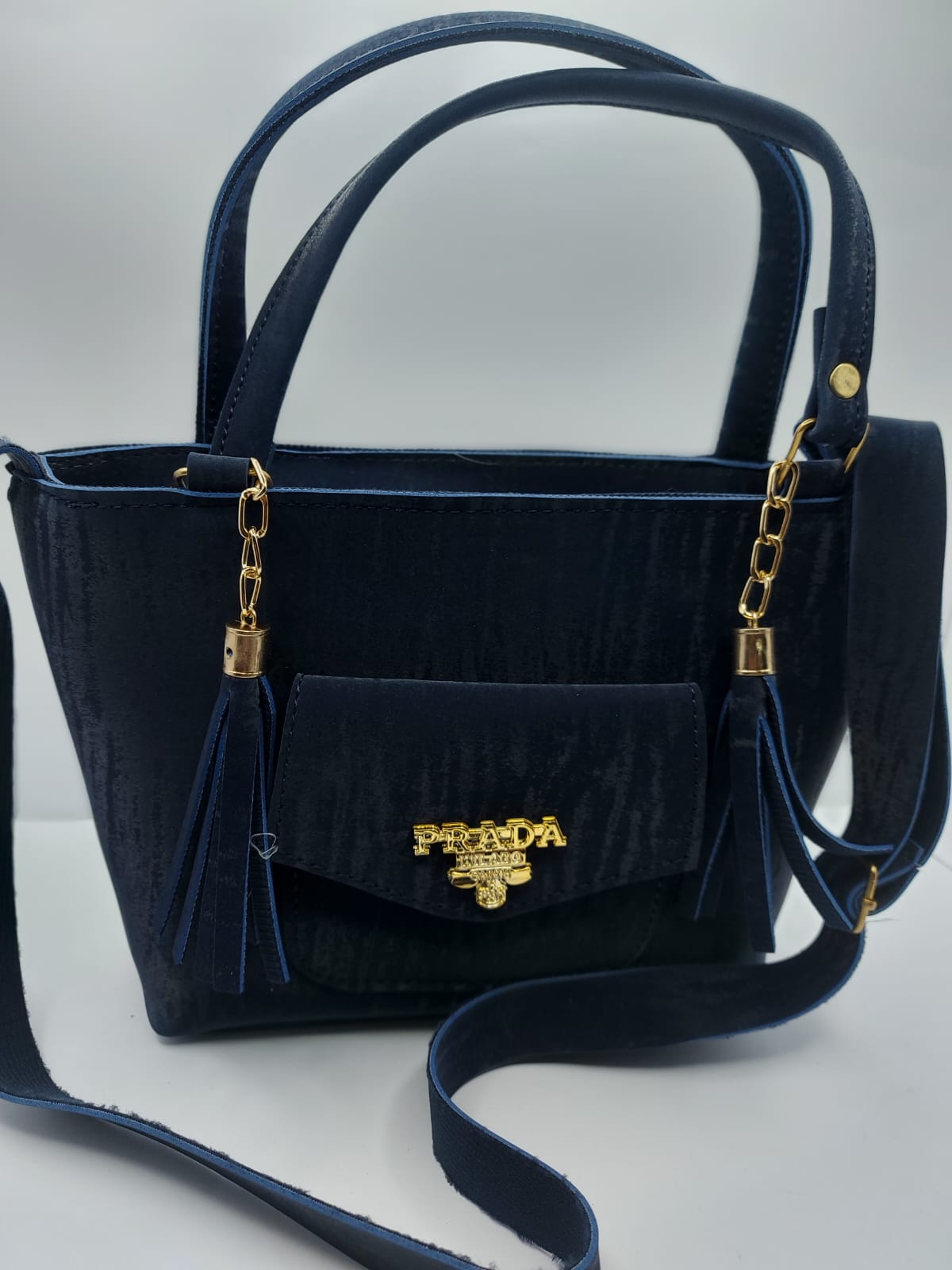 The Navy Velvet Charm Tote Bag offers a blend of luxury and functionality with its plush velvet texture, gold-tone chain accents, and versatile carrying options