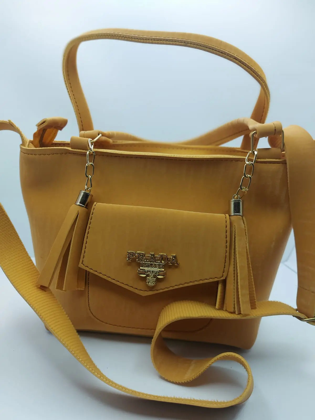 The Mustard Velvet Charm Tote Bag exudes elegance with its plush velvet texture, gold-tone chain accents, and versatile carrying options, perfect for any occasion