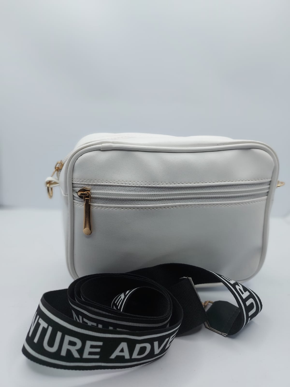Elegant white quilted crossbody bag with a gold-tone logo plate and a trendy adjustable strap for a chic everyday look