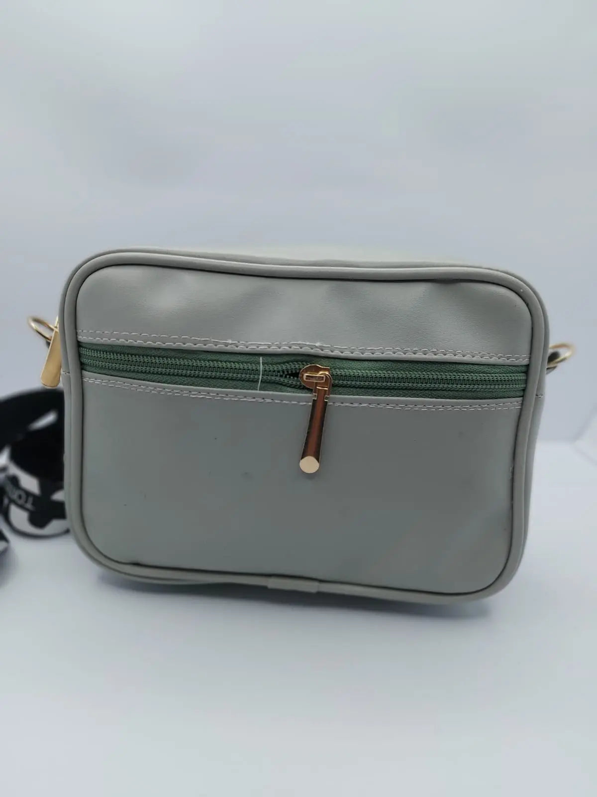 Chic light grey quilted crossbody bag with a gold-tone logo plate and a trendy adjustable strap for a modern everyday look.