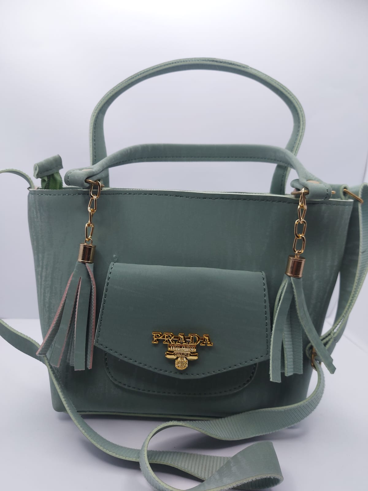 Stylish sage green velvet tote bag with gold chain and tassel design.