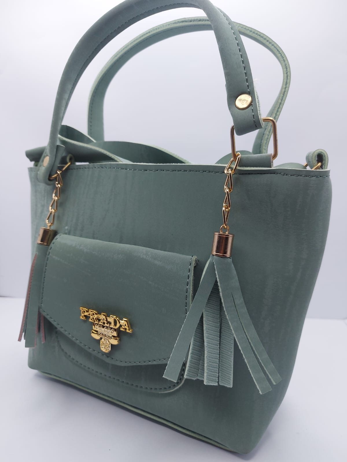 Stylish sage green velvet tote bag with gold chain and tassel design.
