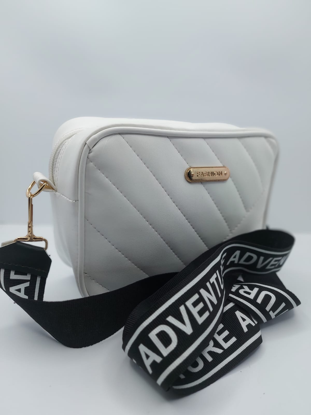 Elegant white quilted crossbody bag with a gold-tone logo plate and a trendy adjustable strap for a chic everyday look
