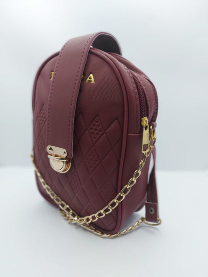 Compact Maroon Crossbody with secure strap lock and leather shoulder pad, perfect for essentials and a chic everyday style.
