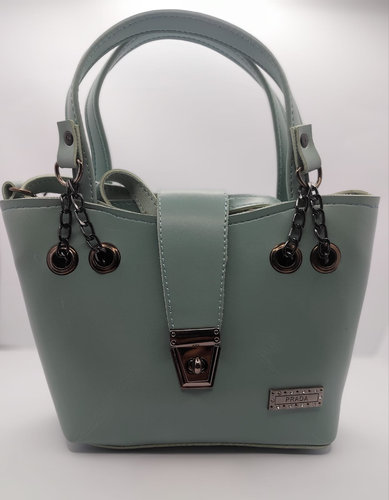 Mint Green tote bag with metallic twisted lock, crafted from premium PU leather. Features hand tote and adjustable shoulder straps, dual zippers for storage, and a sleek solid design with metallic details. Ideal for daily use or special occasions

