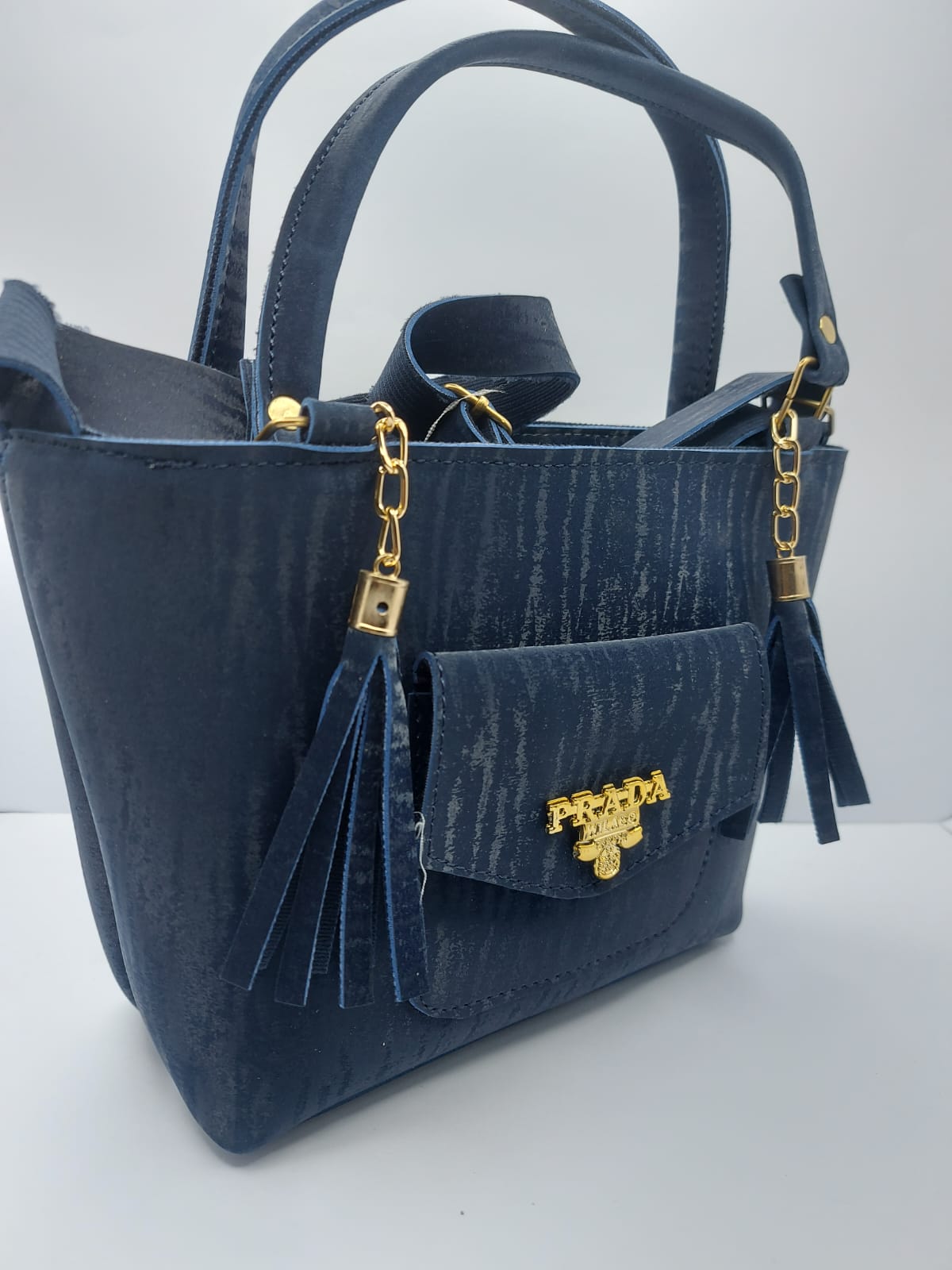 The Navy Velvet Charm Tote Bag offers a blend of luxury and functionality with its plush velvet texture, gold-tone chain accents, and versatile carrying options